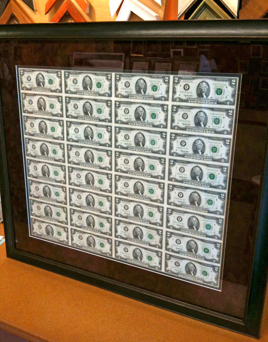 Неразрезанный долларовый лист в рамке